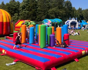 Eight shirts arranged on table in black, olive, grey, blue, white, red, mustard, and green.